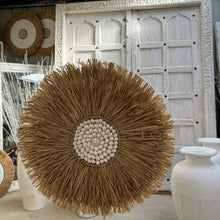 Load image into Gallery viewer, Seagrass Juju hat wall feature with a white shell centre.